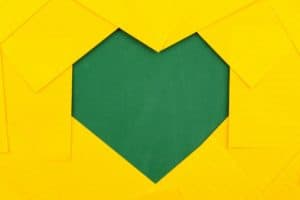 A green heart made by placing yellow pieces of paper